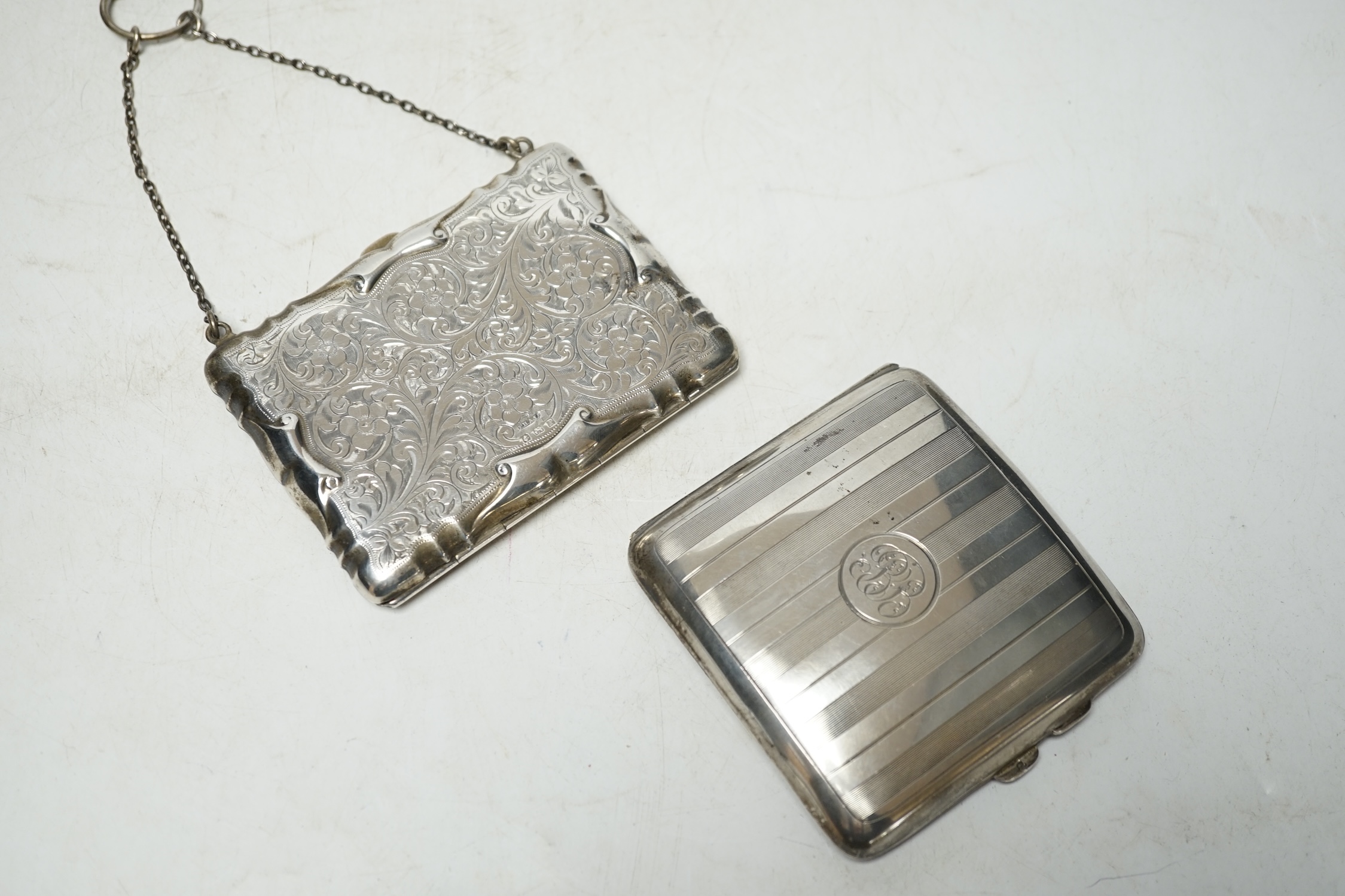 A George V silver cigarette case, 94mm and a George V engraved silver purse (lacking insides). Condition - poor to fair